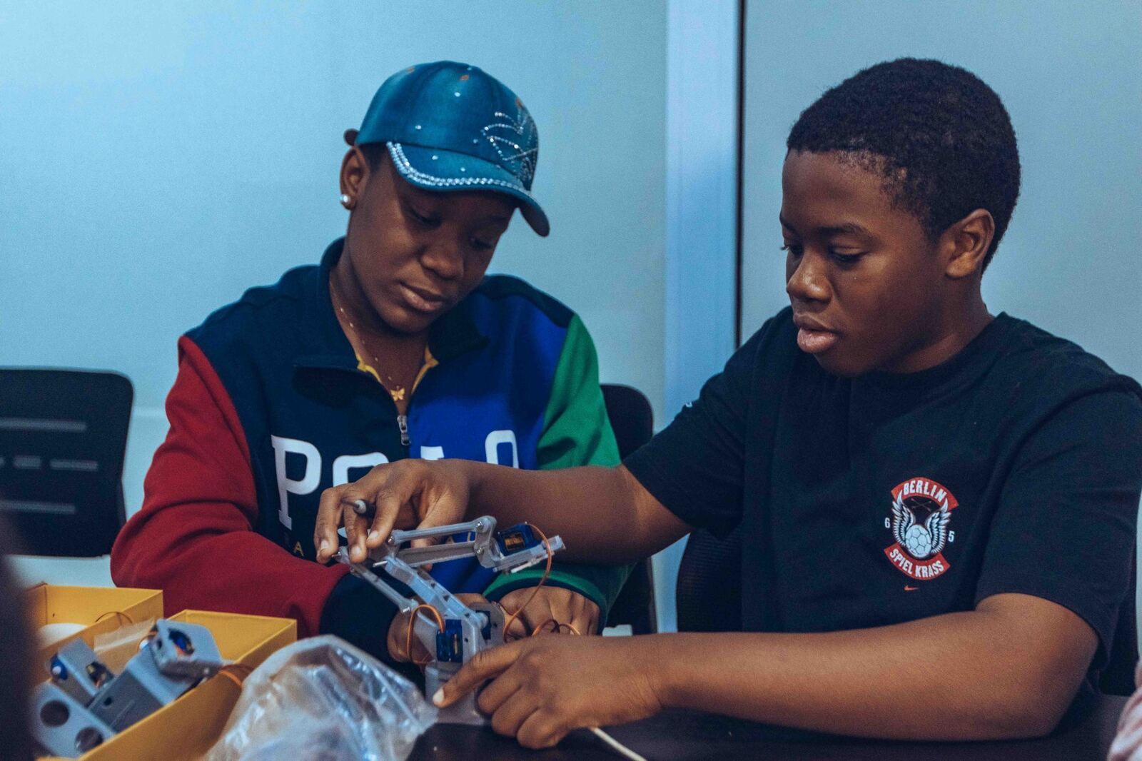 Two teens building a project together